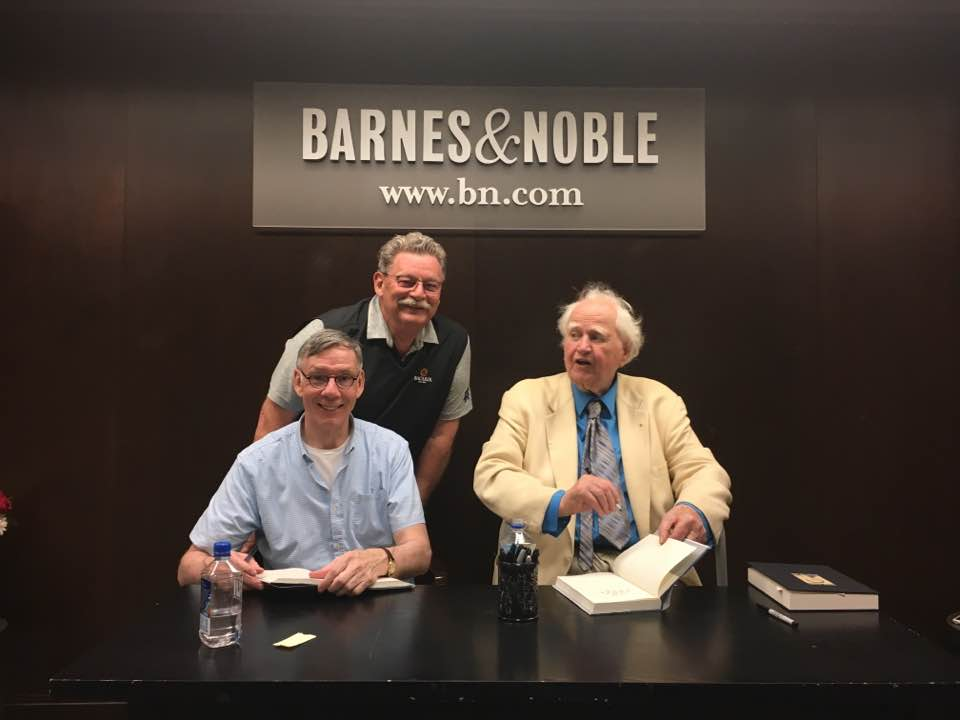Brian McDonald at a book signing event, signing copies for readers.